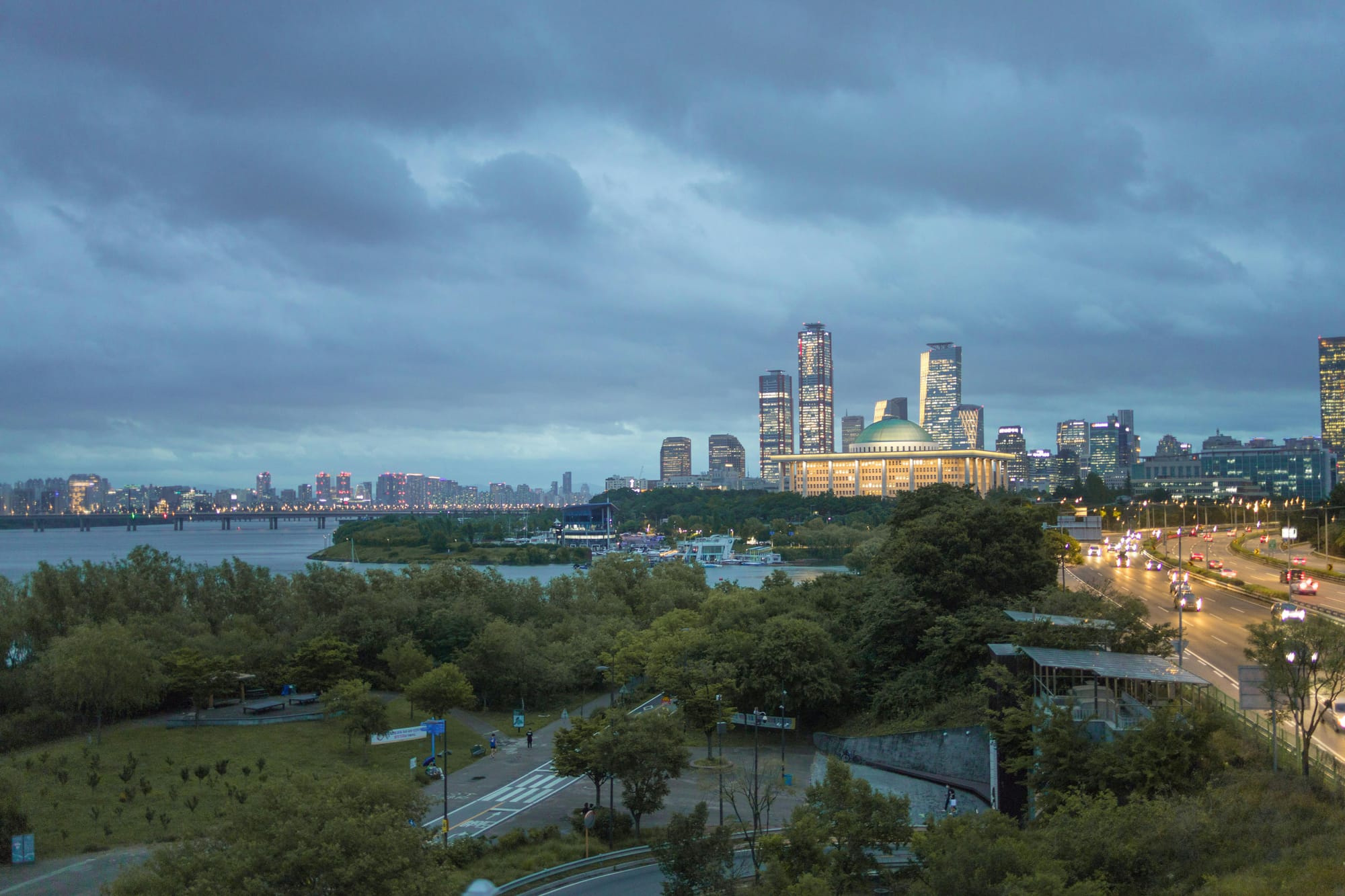 <img src="https://www.pexels.com/ko-kr/photo/15375820/" alt="Blue-hour view of Yeouido in Seoul with the National Assembly building, Han River, and city skyline lights." />