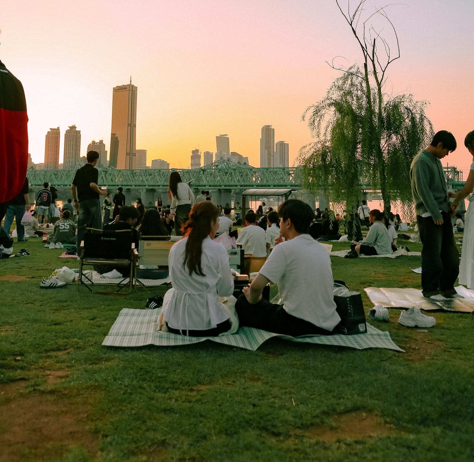 People enjoying a sunset picnic by the river.